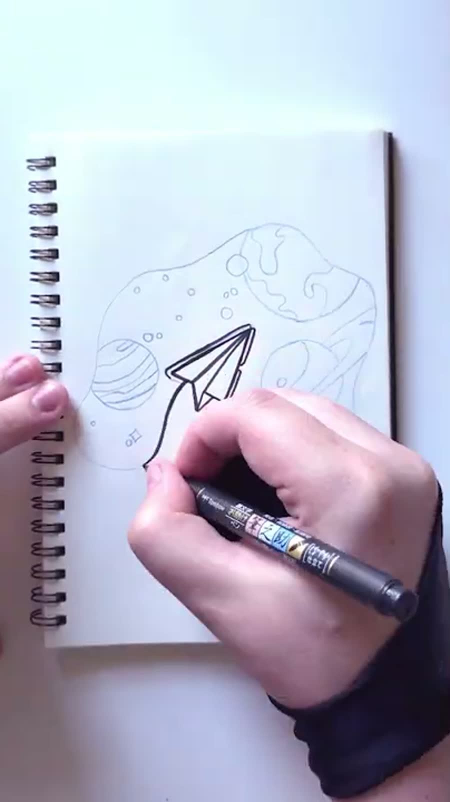 Inktober discover drawing of a paper airplane flying through space and planets.
