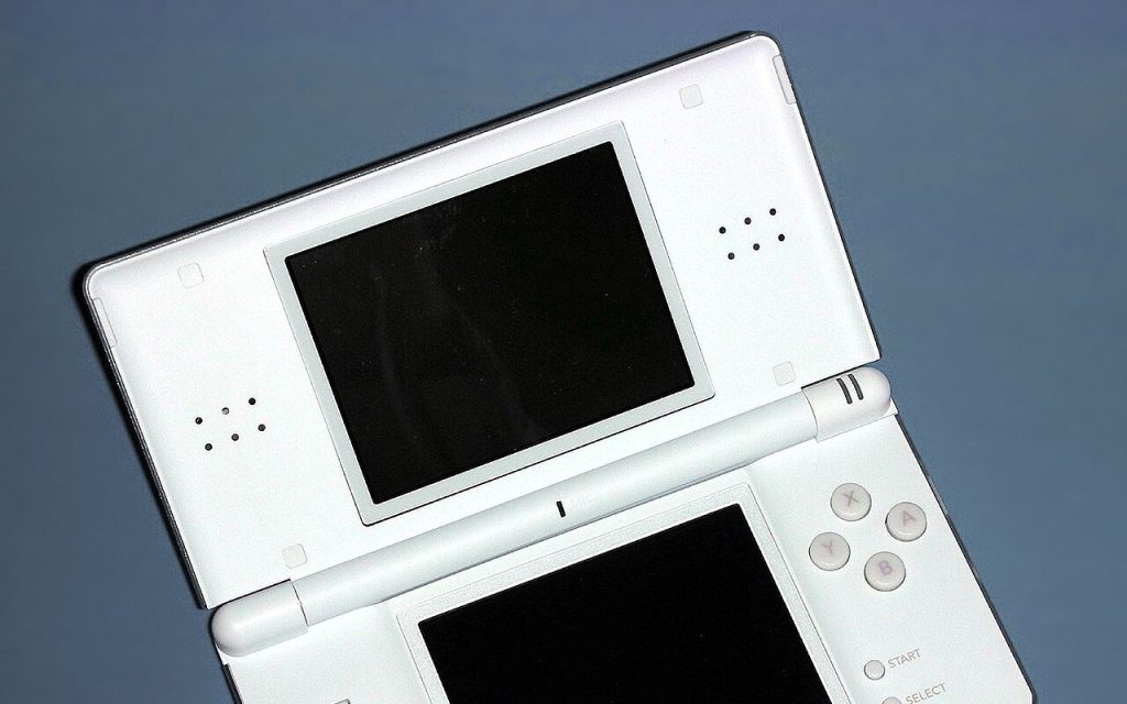 White Nintendo DS Lite handheld on a blue surface